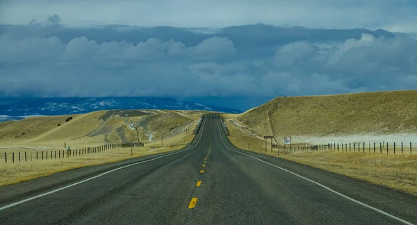 Auto-estrada interestadual atravessa o campo de Montana em direção às colinas distantes — Fotografia de Stock