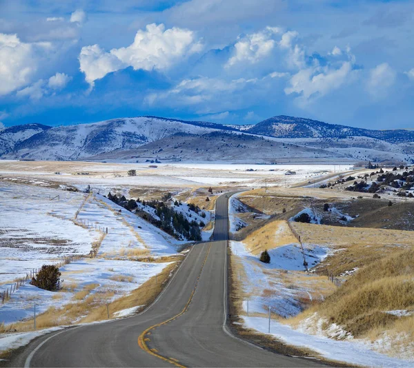 Пустое шоссе проходит по красивой сельской местности Монтаны ранней весной. — стоковое фото