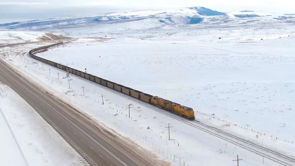 DRONE: Locomotief vervoert auto 's vol kolen door de winterse Verenigde Staten — Stockfoto