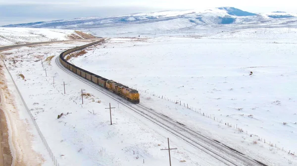 AERIAL: Vliegen langs een locomotief die steenkool vervoert door besneeuwde Verenigde Staten — Stockfoto