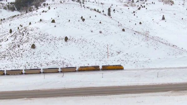 AERIAL: Vista do drone de uma locomotiva de carga que transporta carvão no inverno. — Fotografia de Stock