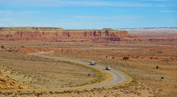 Due camion guidano lungo l'autostrada vuota che attraversa il deserto dello Utah. — Foto Stock