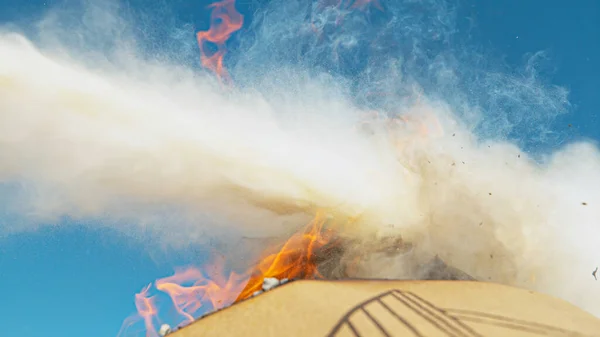CHIUDI: La schiuma estintore spegne un pezzo di cartone inghiottito dalla fiamma. — Foto Stock