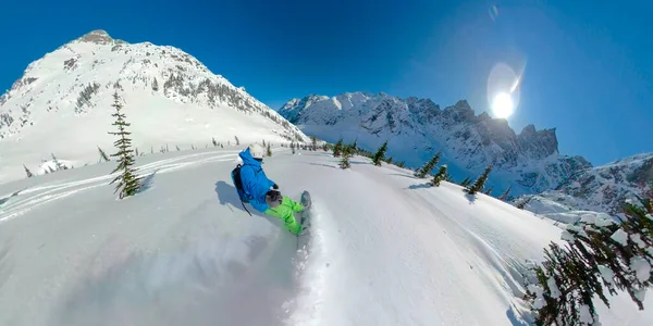 SELFIE : Le snowboarder masculin pulvérise de la neige de fumée froide tout en creusant la montagne. — Photo