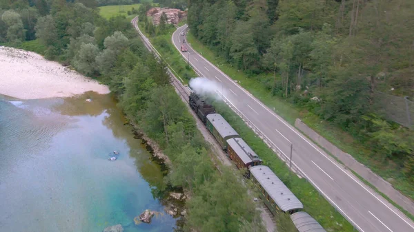 DRONE: Museo locomotora de vapor viaja a lo largo de un hermoso río y carretera rural. —  Fotos de Stock