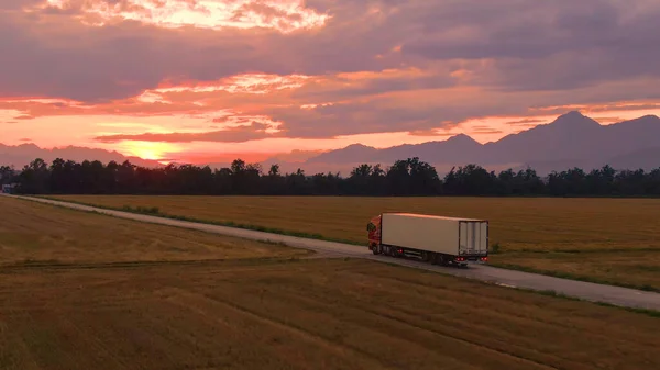 DRONE: Lorry drives goods towards a logistics center on a sunny summer evening. — Stock Photo, Image