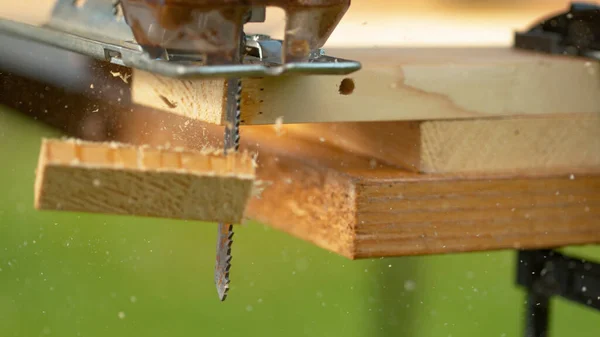 MACRO: Serragem voa de uma lâmina de metal como o quebra-cabeças corta em uma peça de trabalho . — Fotografia de Stock