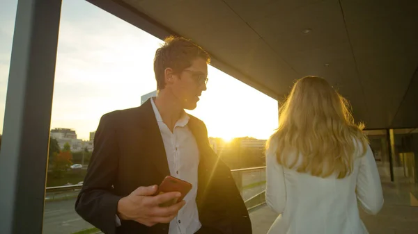 De man kijkt naar de vrouw nadat hij hem tegen het lijf liep terwijl hij sms 'te en liep.. — Stockfoto