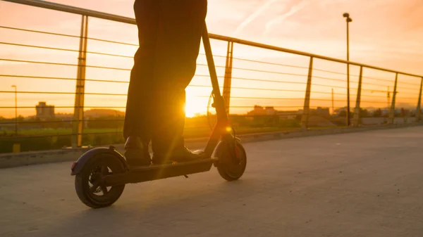 Sluiten: Moderne zakenman geniet van een rit naar huis van het werk op een e-scooter. — Stockfoto
