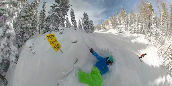 SELFIE: Iniciante esquiador cai em neve profunda em pó ao lado de sinal de aviso amarelo. — Fotografia de Stock