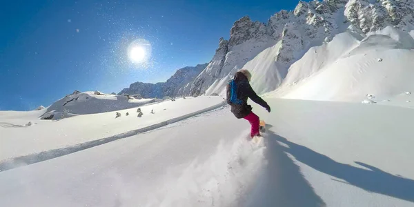 SUIVI : Jeune femme déchiquète la neige fraîche en poudre pendant le snowboard hors piste. — Photo