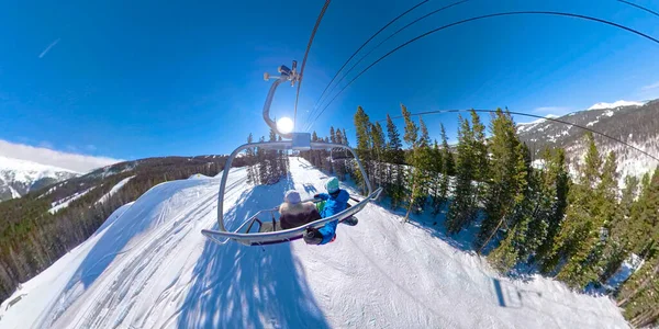 Colorado 'da kar kayağı yapan aktif bir çift manzaralı bir sandalye kaldırma turunun tadını çıkarıyor.. — Stok fotoğraf
