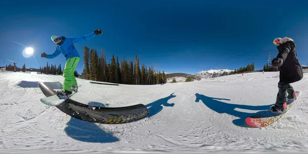 Snowboardistka si vezme selfie svého přítele, jak dělá kosatku podél zábradlí. — Stock fotografie