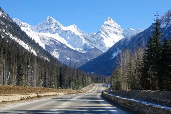 空のアスファルト高速道路は雪の山の息をのむような景色を提供しています — ストック写真
