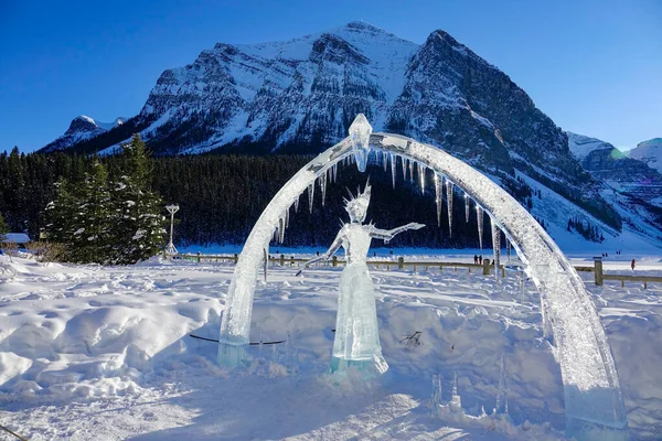 Gorgeous ice sculpture of a princess faces the breathtaking snowy mountains. — Stock Photo, Image