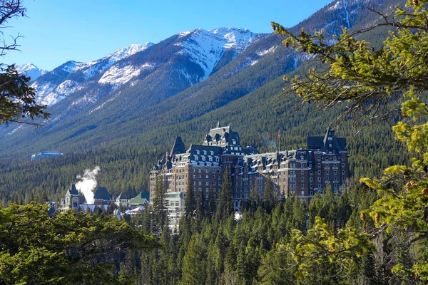 Warm spring sunbeams shine on the infamous spooky Fairmont Banff Springs Hotel. — Stock Photo, Image