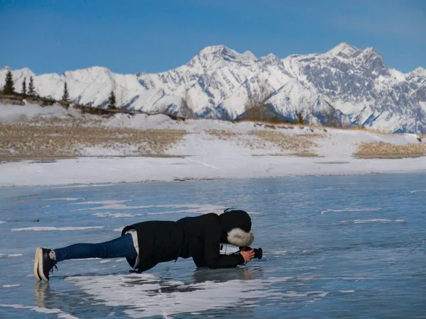 女摄影师拍摄亚伯拉罕湖光滑冰冻表面的照片. — 图库照片