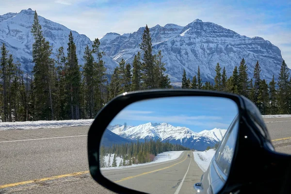 CLOSE UP: Side mirror view of Icefields Parkway route and snowy mountains. — Stock Photo, Image