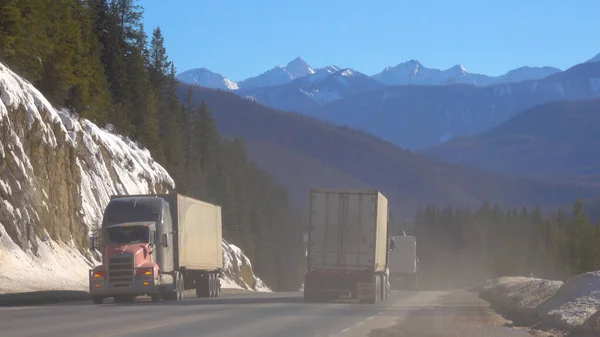 Freight trucks transport containers across the picturesque Banff National Park. — Stock Photo, Image