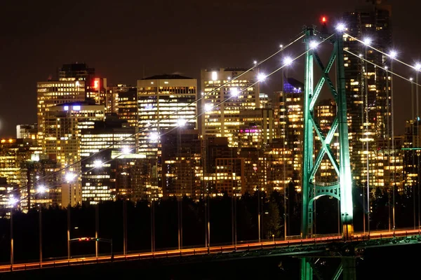 CLOSE UP: Szenischer Blick auf die beleuchtete Skyline von Vancouver und eine große Brücke. — Stockfoto