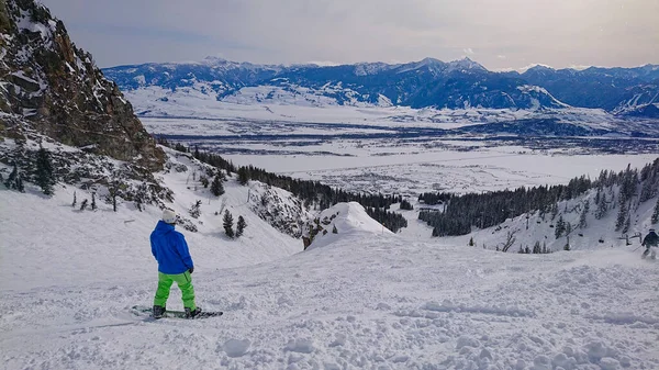 Snowboarder megfigyeli a havas táj előtt lovaglás le egy sípálya — Stock Fotó