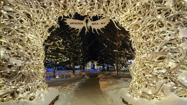 FECHAR UP: Luzes de Natal arco sobre uma passarela em um parque nevado em Jackson Hole. — Fotografia de Stock