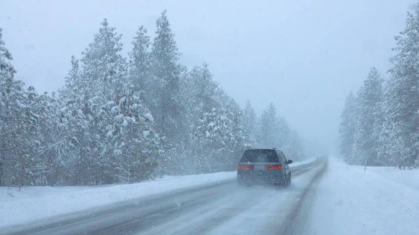 Commuters drive down a snowy country road in Spokane through a severe snowstorm. — Stock Photo, Image