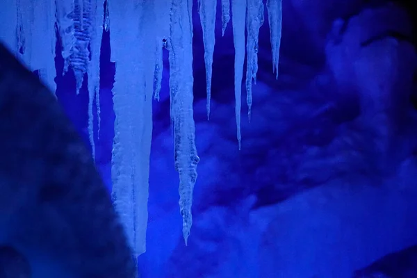 CLOSE UP: Кришталево чисті палички льоду звисають зі стелі замерзлої печери . — стокове фото
