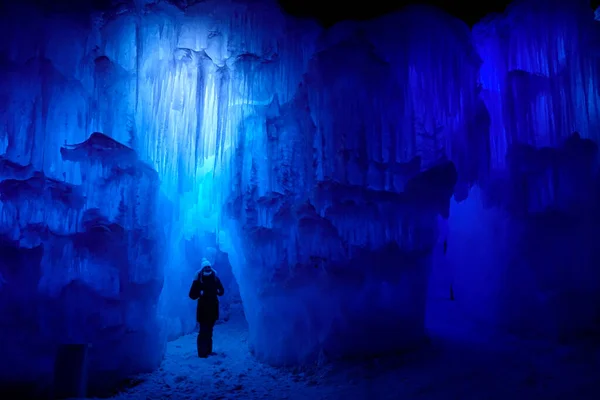 Viaggiatore cammina intorno a un pilastro ghiacciato all'interno di una pittoresca grotta di ghiaccio in Colorado. — Foto Stock
