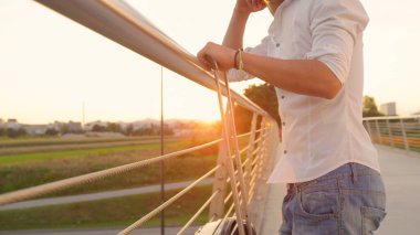 Uçuşunu bekleyen genç adam akşam manzarasını gözlemliyor..