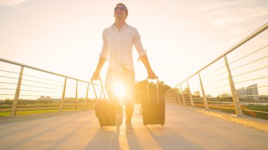 Adamın gün batımında valizlerle havaalanına koştuğu komik bir fotoğraf..