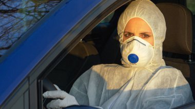 Koruyucu giysili kadın doktor koronavirüs merkezine gidiyor.