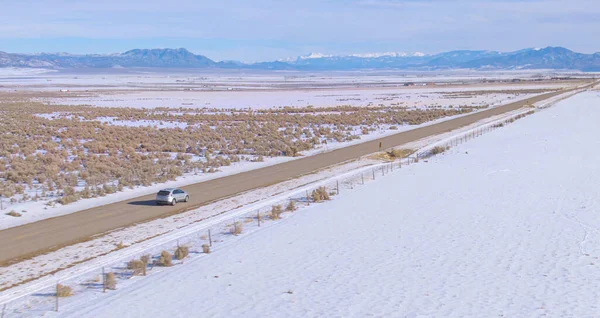 Utah 'tan geçen boş otoyolda gümüş bir araba boyunca uçuyorum.. — Stok fotoğraf