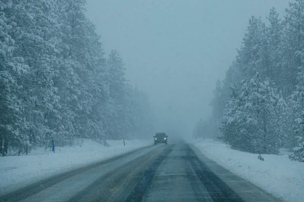 Grande pick up caminhão dirige-se por uma perigosa estrada gelada durante uma tempestade de neve grave. — Fotografia de Stock