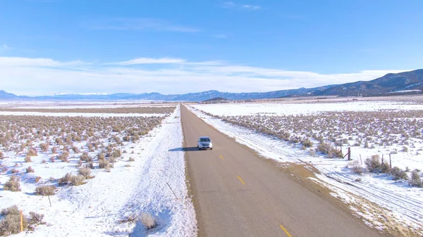 Туристы во внедорожнике исследуют снежные равнины Юты в солнечный зимний день — стоковое фото