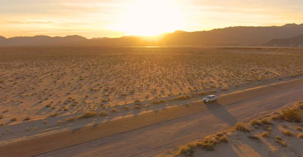 LENS: полет над внедорожником, пересекающим пустыню Мохаве на закате. — стоковое фото