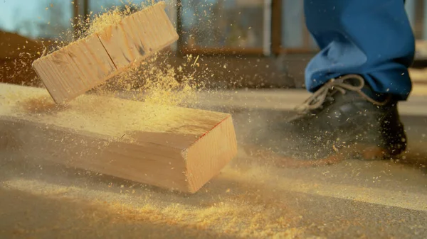 CLOSE UP: Onhandige aannemer hout snijden valt bijna een houten balk op zijn voet. — Stockfoto