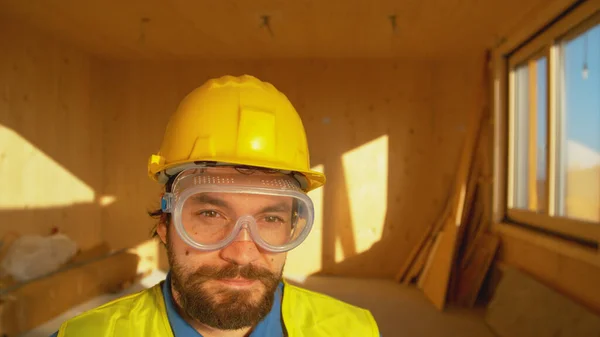 PORTRAIT: Bärtiger Bauarbeiter lächelt während einer Arbeitspause im CLT-Haus. — Stockfoto