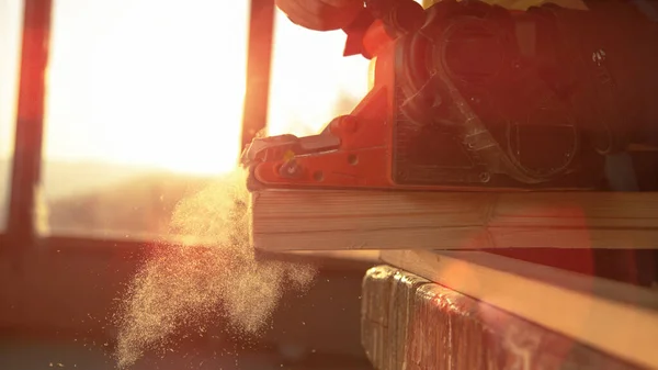 MACRO: αγνώριστη ξυλουργός buffs την πλευρά μιας σανίδας με ηλεκτρικό τριβείο. — Φωτογραφία Αρχείου