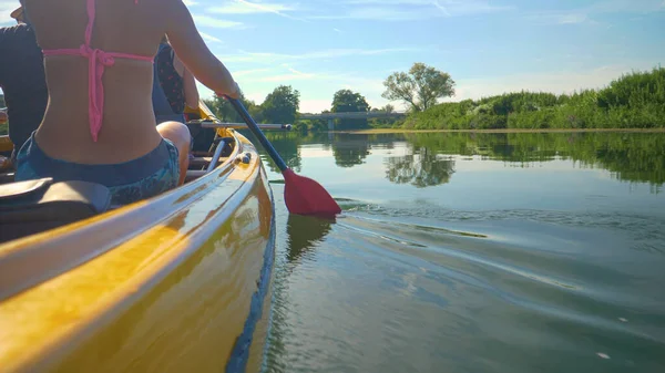 FECHAR-SE: Jovem e mulher remam uma canoa por um rio calmo na Eslovênia. — Fotografia de Stock