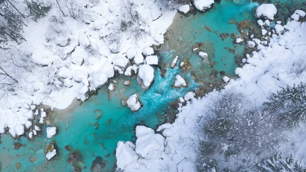 Büyüleyici turkuaz renkli nehir karlı bir ormanın içinden akar.. — Stok fotoğraf