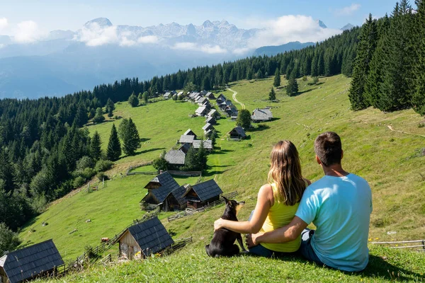 CLOSE UP: Young couple observes the rural mountain landscape with their dog. — 图库照片