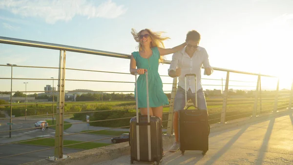 LENS FLARE : Des rayons de soleil dorés brillent sur les jeunes couples en attente de navette aéroport — Photo