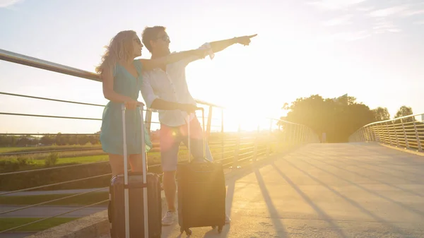 SUN FLARE: Emocionado pontos de casal turístico em seu passeio levá-los ao aeroporto. — Fotografia de Stock