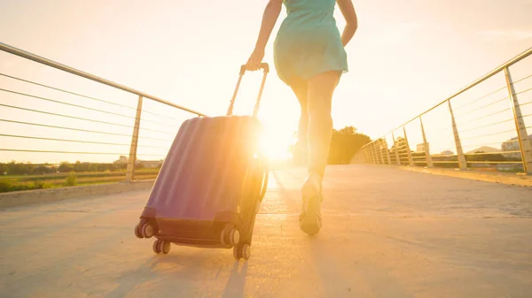 LOW ANGLE: Young tourist with beautiful legs runs to the airport at sunset. — Stock Photo, Image