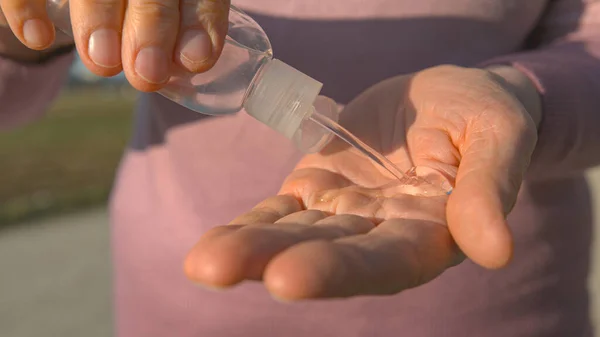 AFSLUITEN: Vrouw die tijdens de uitbraak van het coronavirus alcohol met de hand desinfecteert. — Stockfoto