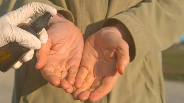 CLOSE UP: Man 's handen worden bespoten met de hand sanitizer tijdens COVID-19 pandemie — Stockfoto