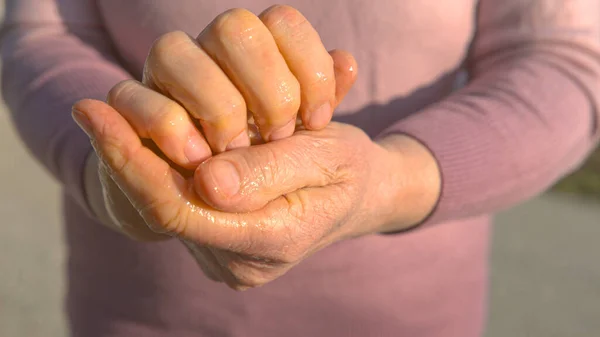 CERRAR: Mujer caucásica frota gel antimicrobiano desinfectante entre sus manos. — Foto de Stock