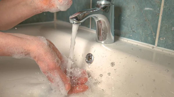 Tanımlanamayan kadın, banyo gezisinden sonra sabunlu ellerini duruluyor.. — Stok fotoğraf