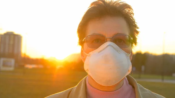 PORTRAIT, DOF: Zonnestralen schijnen op oudere vrouwen die een gezichtsmasker dragen. — Stockfoto